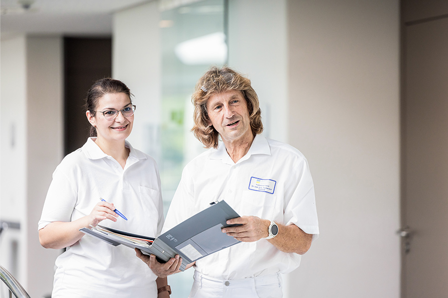 Ein Arzt und eine Pflegekraft schauen in eine Patientenakte. Ein Arzt und eine Pflegekraft schauen in eine Patientenakte.