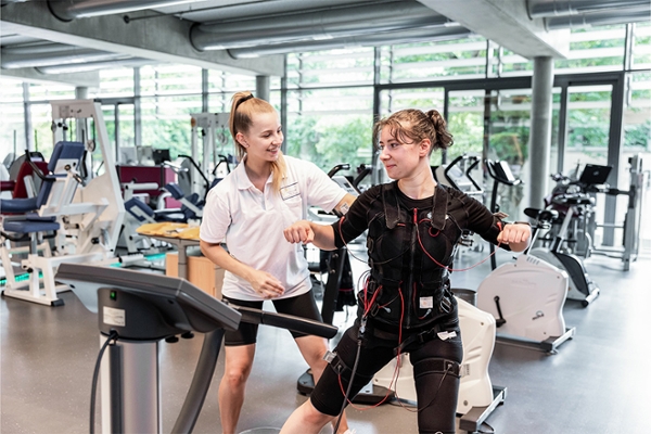 Eine Therapeutin unterstützt eine Patientin bei einer EMS-Behandlung. Eine Therapeutin unterstützt eine Patientin bei einer EMS-Behandlung.